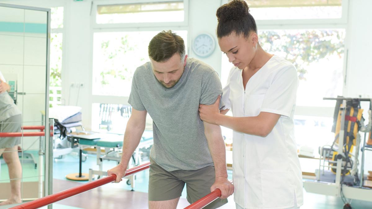 A physio assisting a patient during rehab treatment