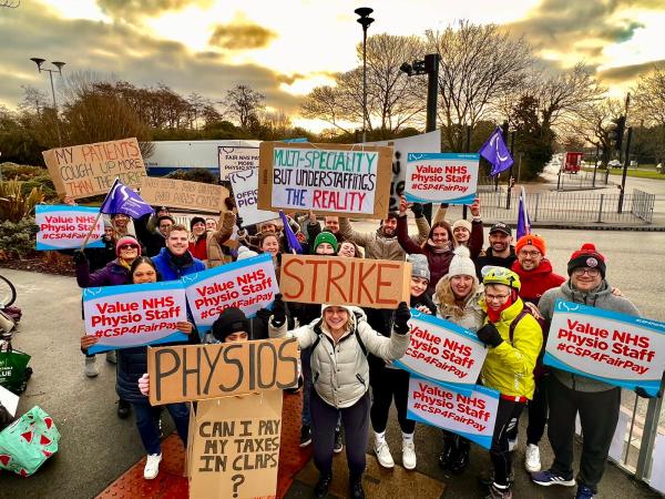 A crowd of CSP members with a variety of home-made banners