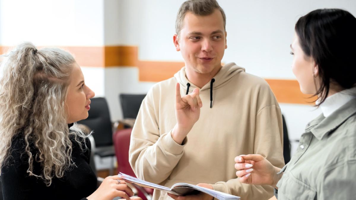 A group of three young learners networking together in a meeting room